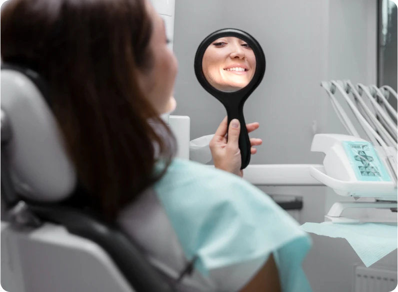 Paciente a avaliar o resultado do seu sorriso no consultório de medicina dentária estética.