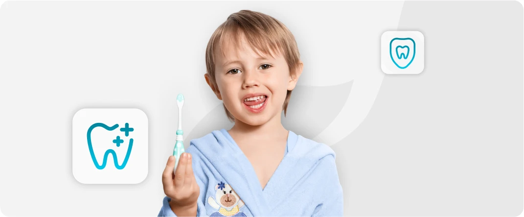 Menino a sorrir com uma escova de dentes na mão.