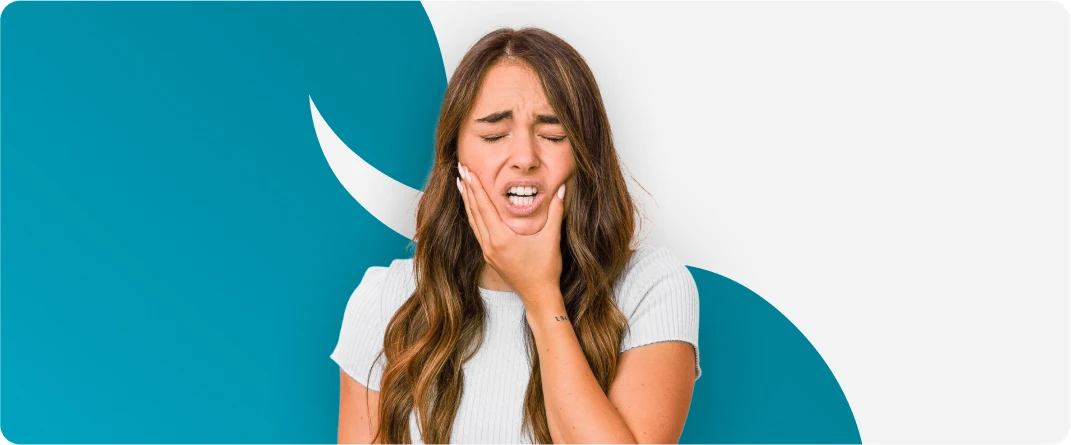 Mulher com dor de dentes e mão na boca.