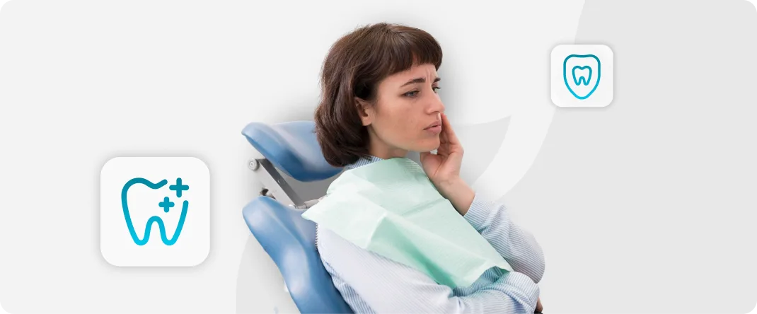 Mulher com a mão no maxilar, mostrando dor dentária causada por cáries em dentes desvitalizados