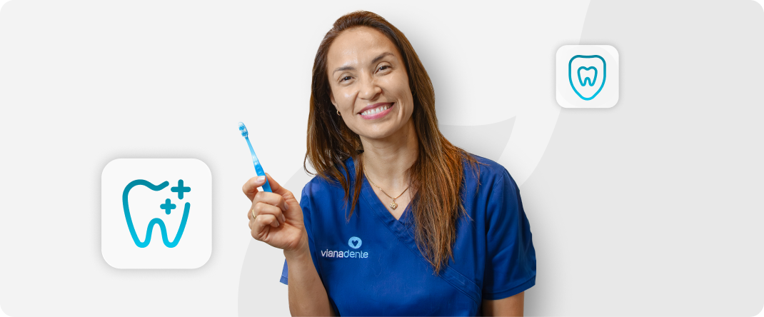 Dentista da Vianadente a segurar uma escova de dentes e a demonstrar a escovagem correta para uma boa higiene oral.